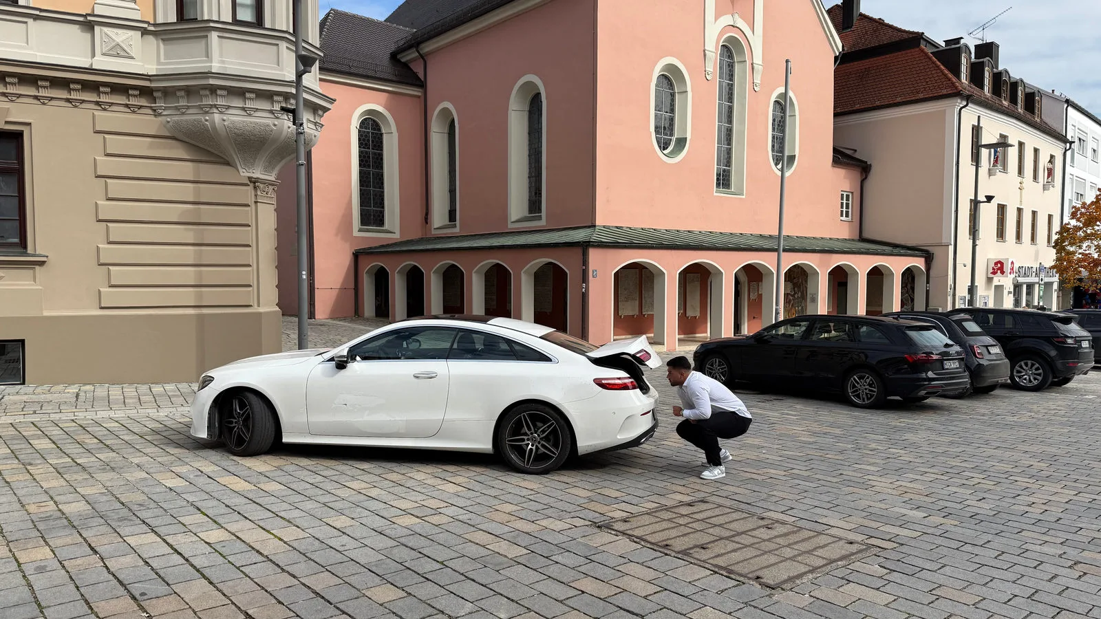 Diren Köysüren begutachtet das Heck eines weißen Mercedes Coupés