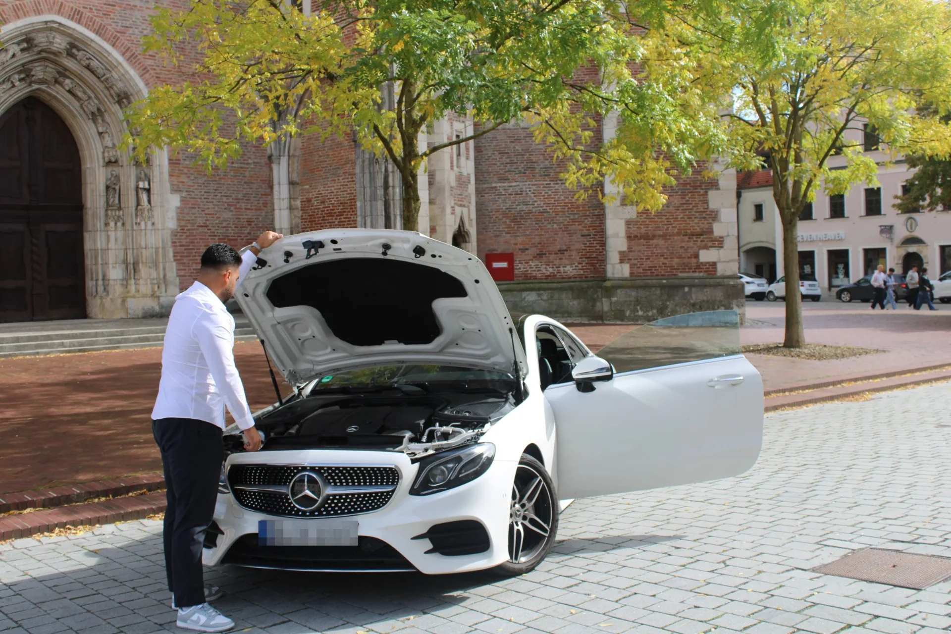 Diren Köysüren begutachtet den Motorraum eines weißen Mercedes