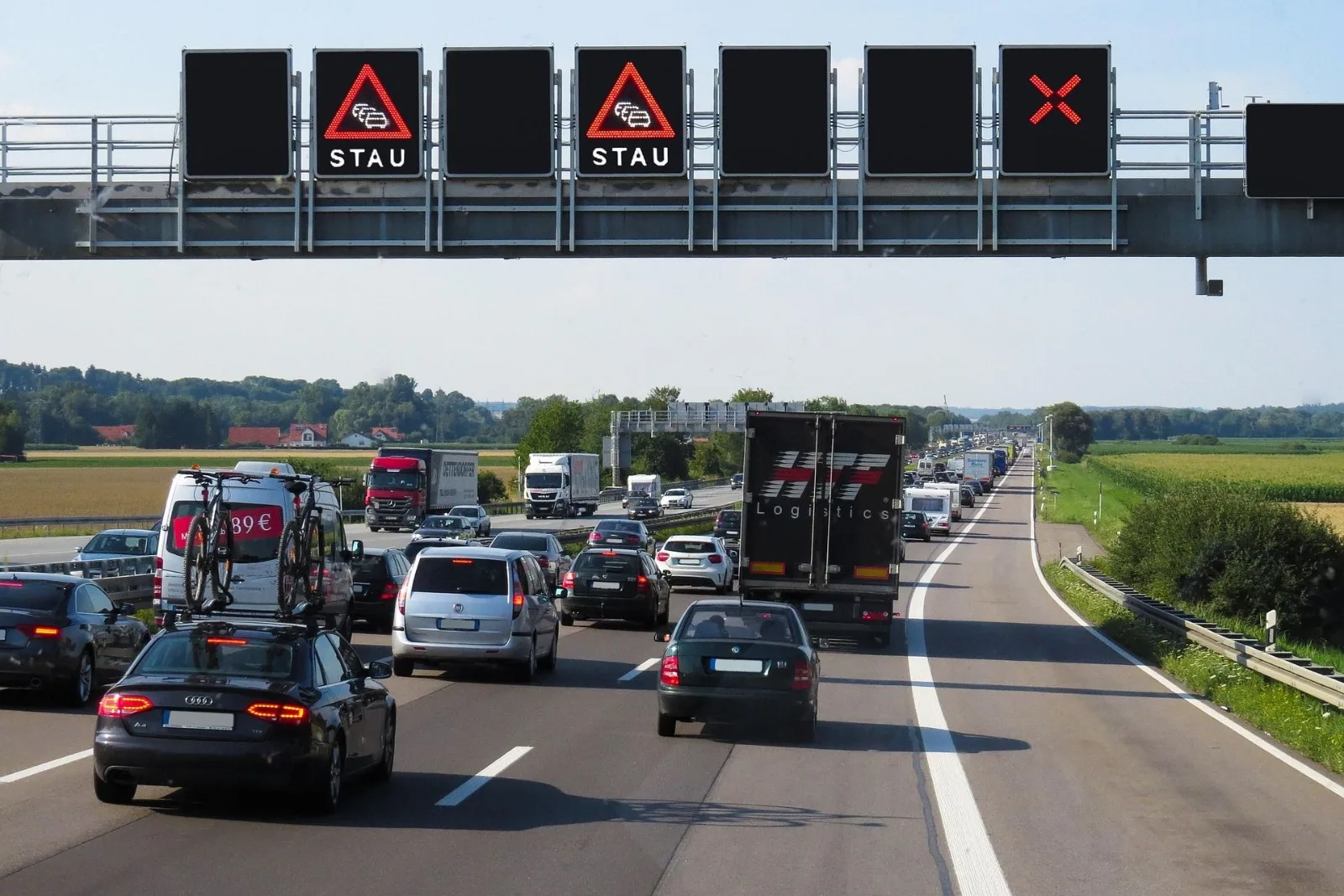 Stau auf der Autobahn mit Staumeldung auf der Anzeigetafel: Kettenauffahrunfall, wer zahlt bei mehreren Fahrzeugen